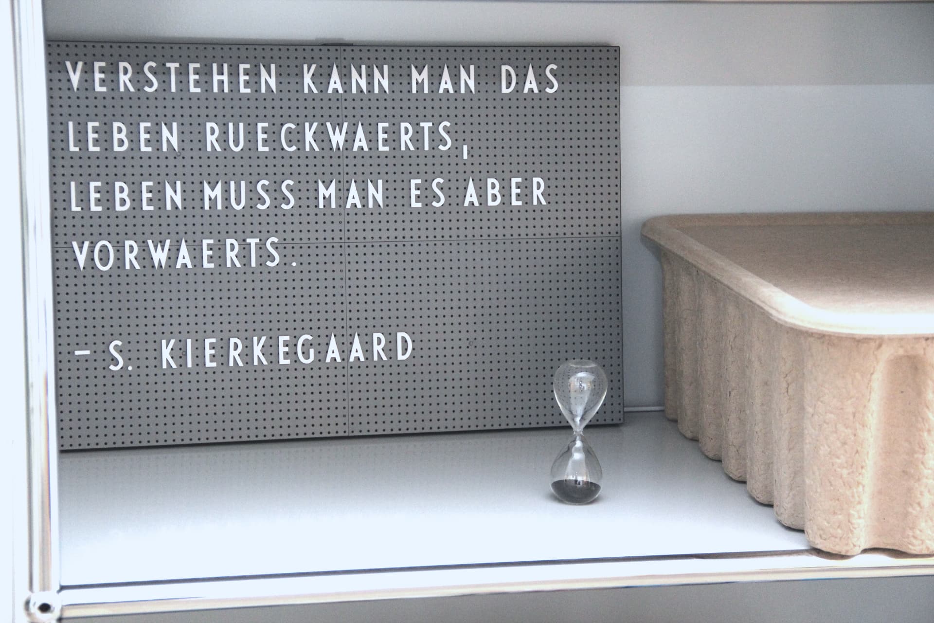 Zitattafel von S. Kierkegaard im Praxisregal: Verstehen kann man das Leben rückwärts, leben muss man es aber vorwärts