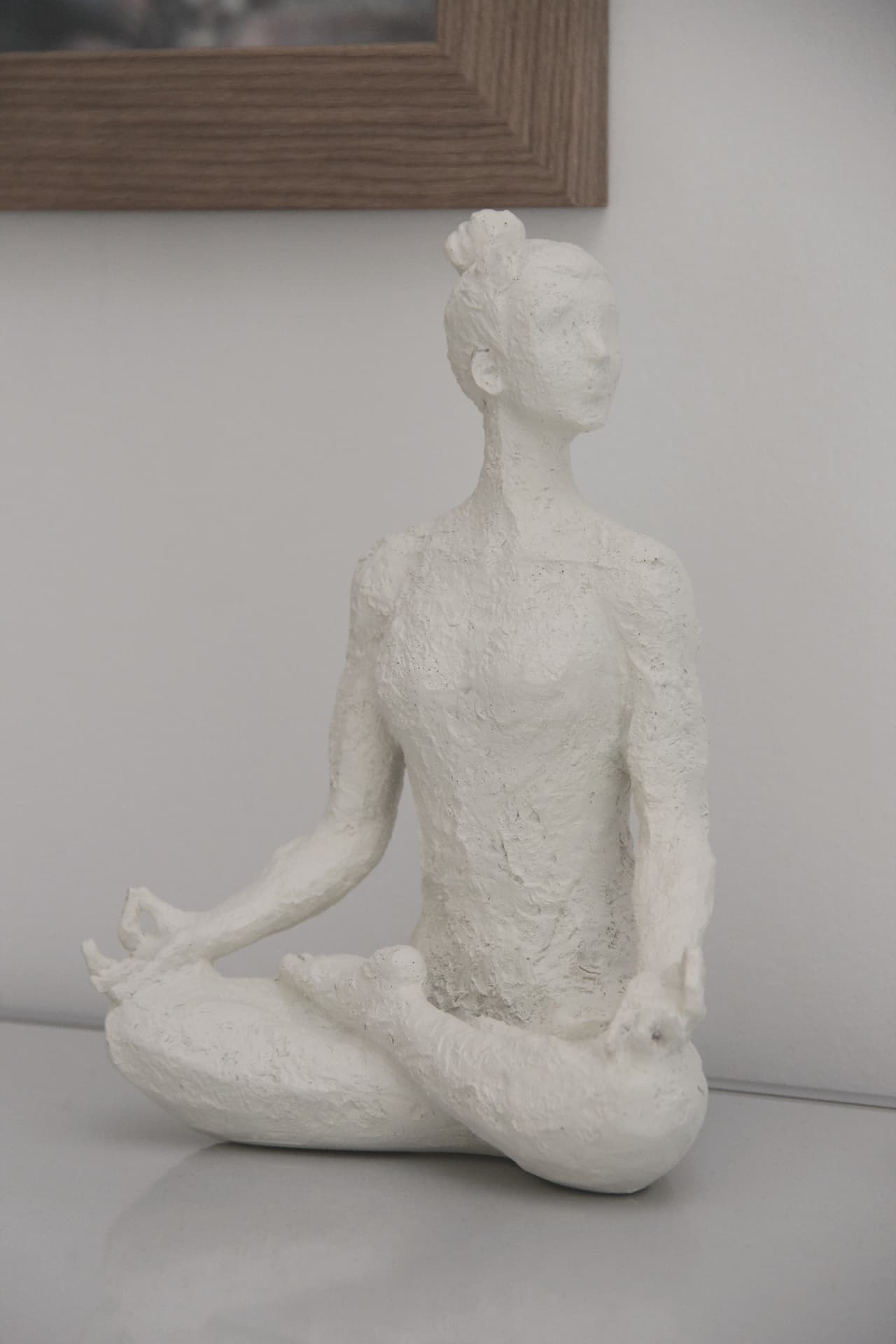 Weiße Skulptur einer meditierenden Figur als Symbol für Achtsamkeit und Ruhe
